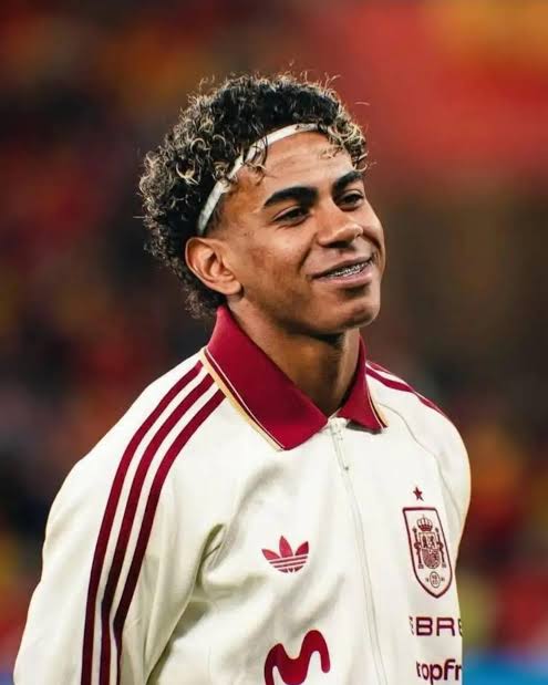 Lamine Yamal, FC Barcelona's No. 10, smiling in the Spain national team kit before a match